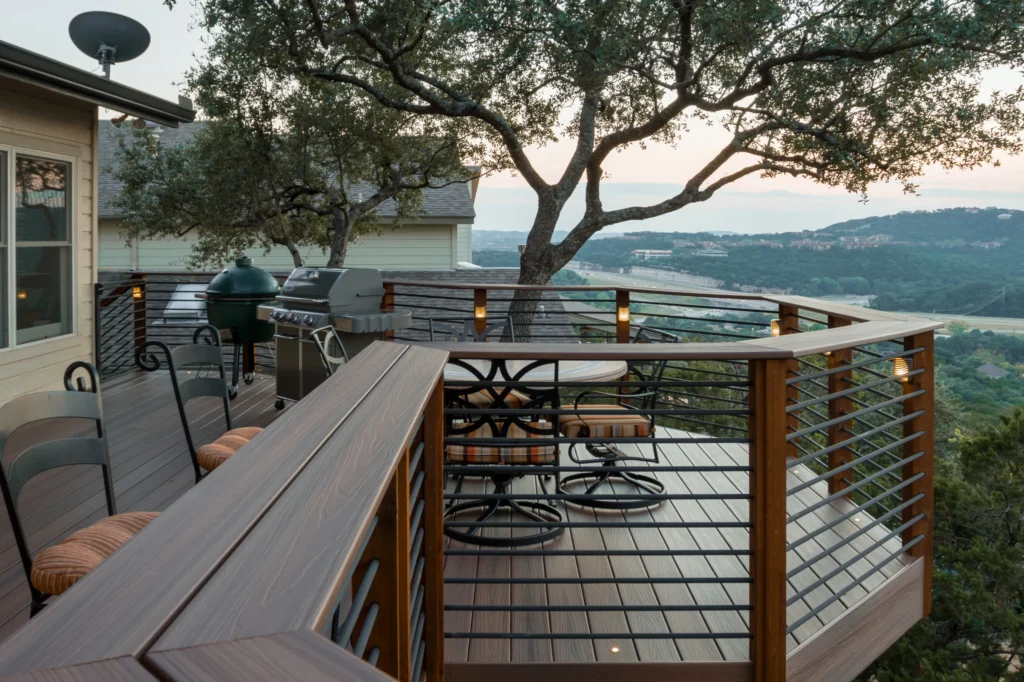 High-elevated composite deck featuring dark cable railings, outdoor grill, and scenic valley view.