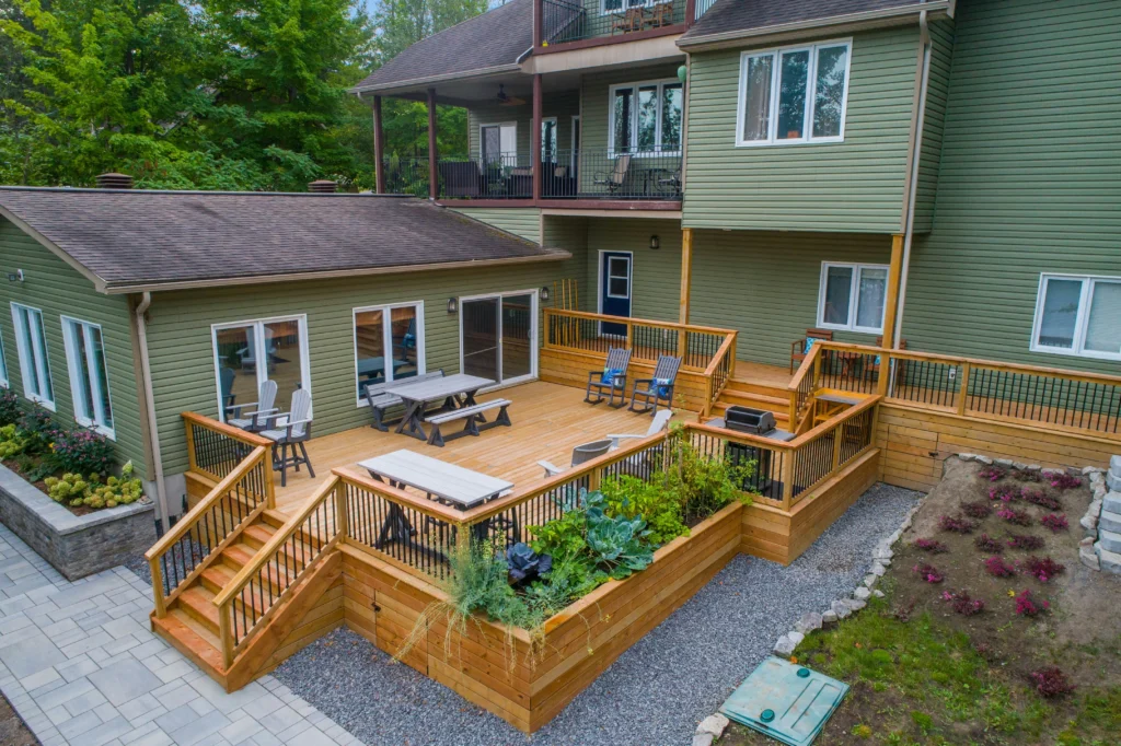 Large multi-level natural wood deck featuring built-in wooden planter boxes, railing, and garden stairs.